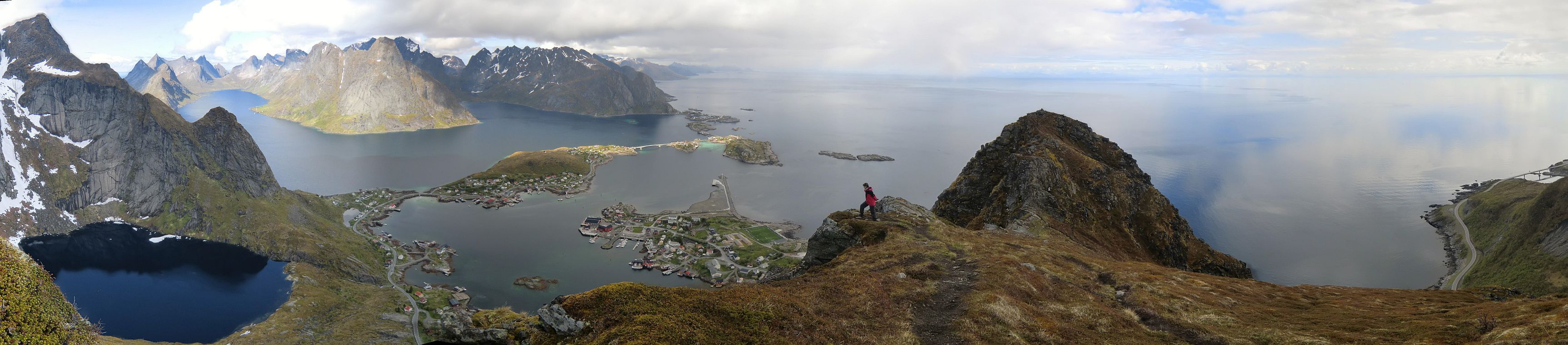 Panoramablick von links - Kjerkfjord, Reine, der Gipfel des Reinebringen, die E10 nach 